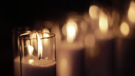 velas encendidas en vasos de vidrio anchos