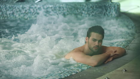 hombre relajándose en el spa en vacaciones. hombre descansando en el jacuzzi en el centro de bienestar