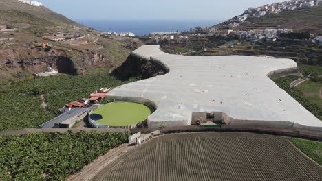 Fantstic-dolly-in-aerial-view-over-banana-plantations-and-greenhouses-very-close-to-the-coast,-in-Tenoya,-on-the-island-of-Gran-Canaria-and-on-a-sunny-day