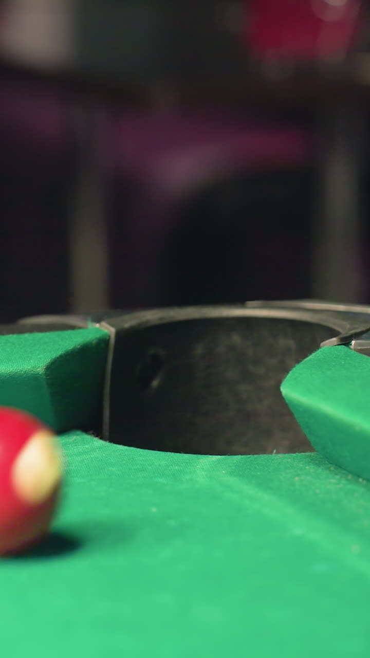 en un fondo borroso, el primer plano captura la pelota de billar roja rodando rápidamente en el bolsillo de la mesa de billar en la superficie verde. el borrón de movimiento destaca la velocidad, la precisión, la tensión y la emoción competitiva