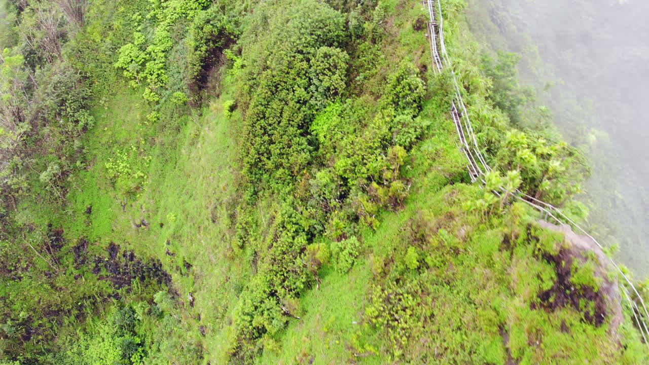 vista aérea de la escalera al cielo en hawai con escalera en un acantilado desapareciendo en las nubes