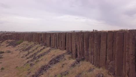 vuelo rápido a lo largo de la cara del acantilado de columnas de roca volcánica en wa scablands