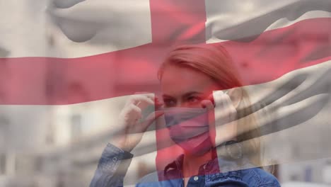 animation of flag of england over woman wearing face mask