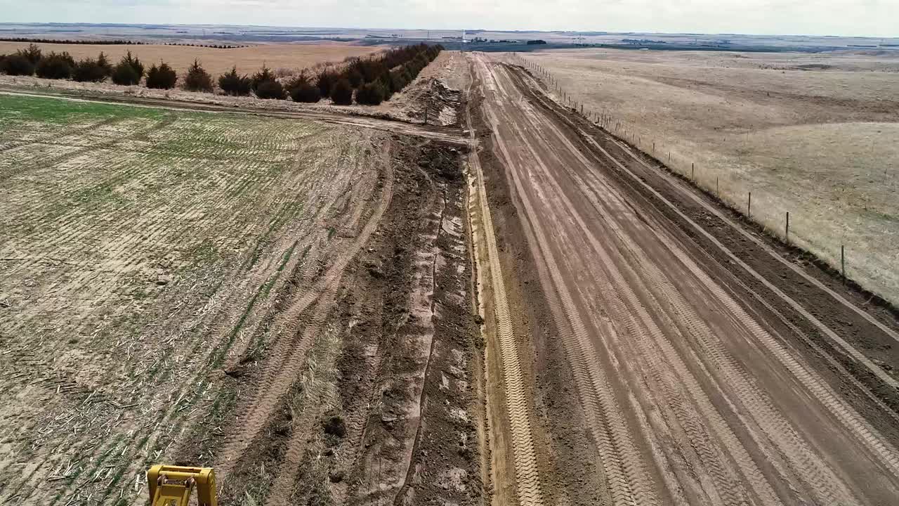 Motoniveladora trabalhando em vala de drenagem em estrada de terra