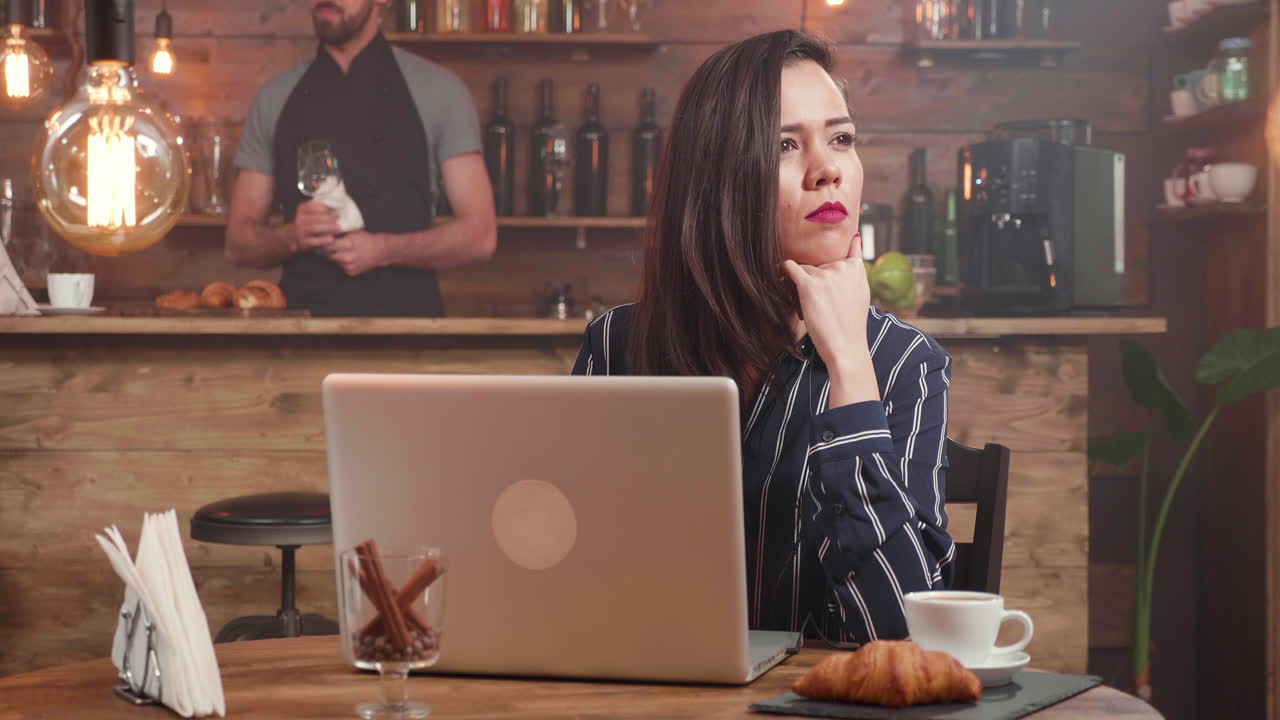 Donna che lavora al computer portatile in un caffè