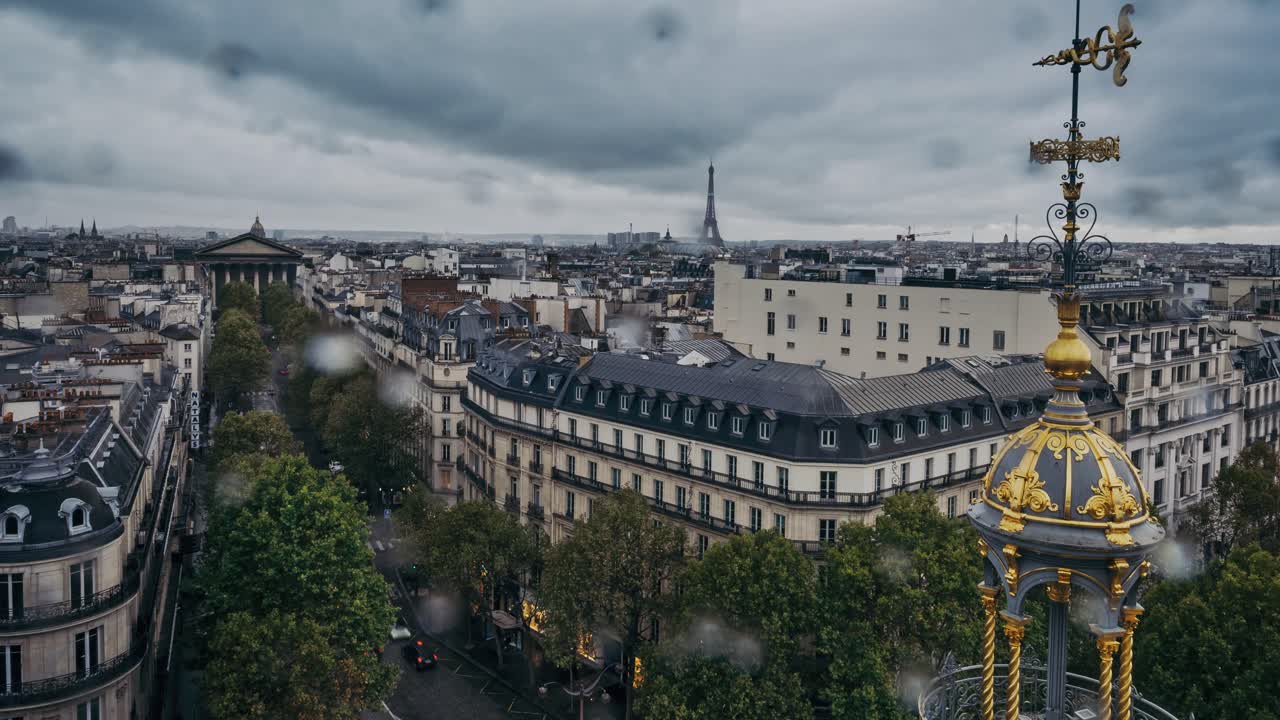 Przyspieszony lotniczy widok (time lapse) w deszczu, w górę ulicy Tronchet w kierunku Madeleine i Wieży Eiffla, Paryż, Francja