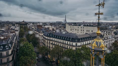 Aerial-time-lapse-in-the-rain-of-view-up-Rue-Tronchet-towards-the-Madeleine-and-Eiffel-Tower,-Paris,-France