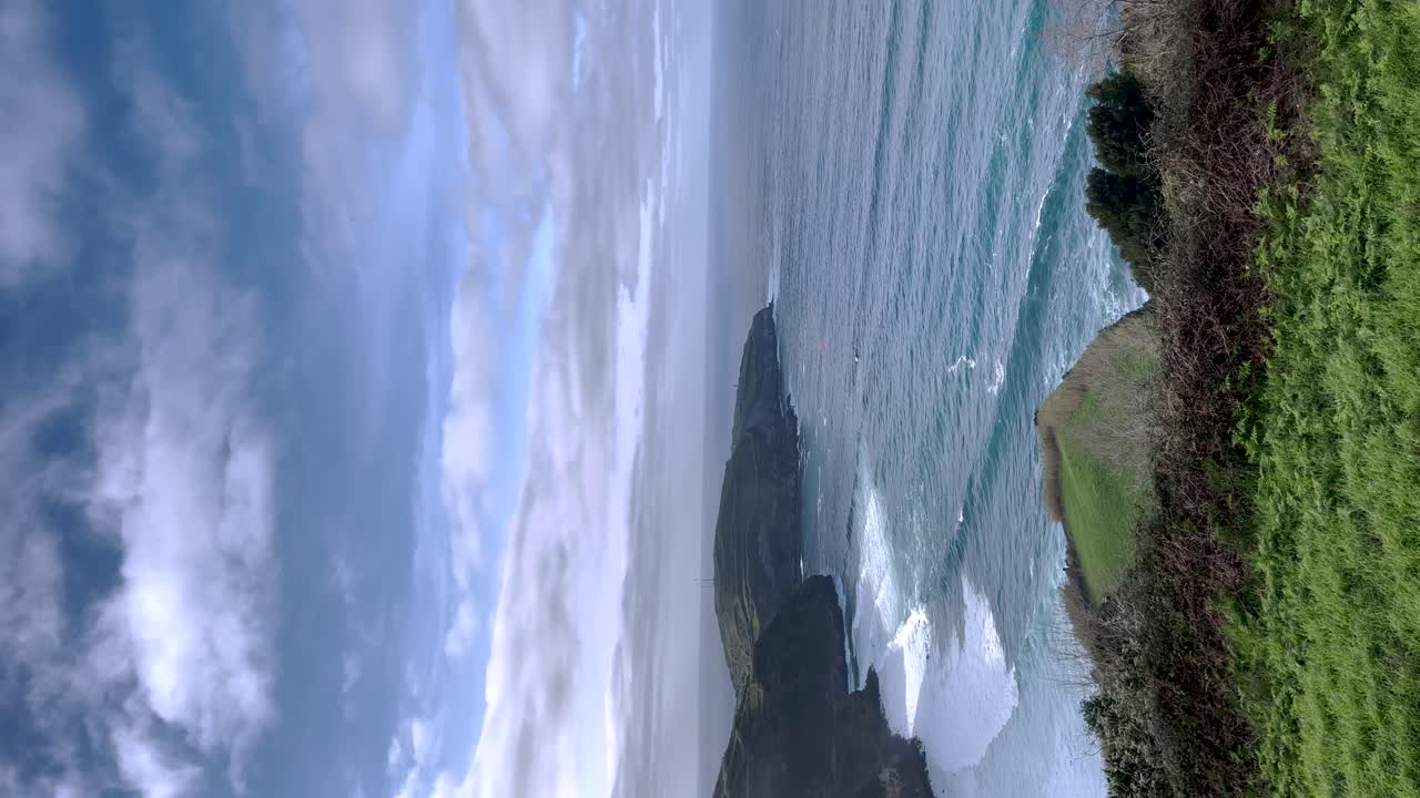Ocean waves in a vertical video, as they gracefully cascade onto the shores of the Portuguese Riviera in the Azores, Portugal, embodying the tranquil coastal allure and awe-inspiring natural beauty
