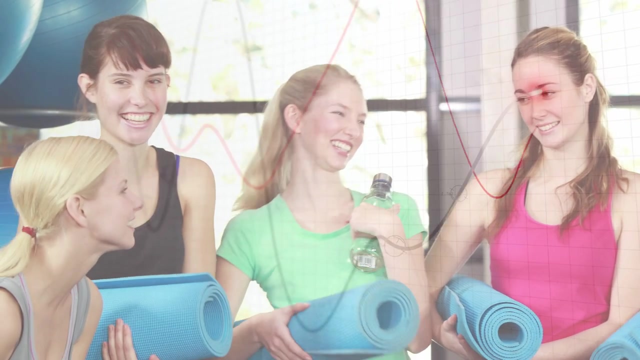 Donne che si preparano per una lezione di yoga, la telecamera panoramica rivela un gruppo che tiene tappetini blu e bottiglie