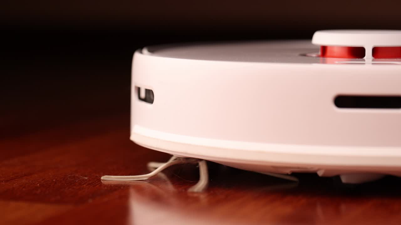 나무 바닥에 리더를 가진 스마트 로 진공청소기 로 진소기는 아파트의 자동 청소를 수행합니다. 느린 동작 100fps.