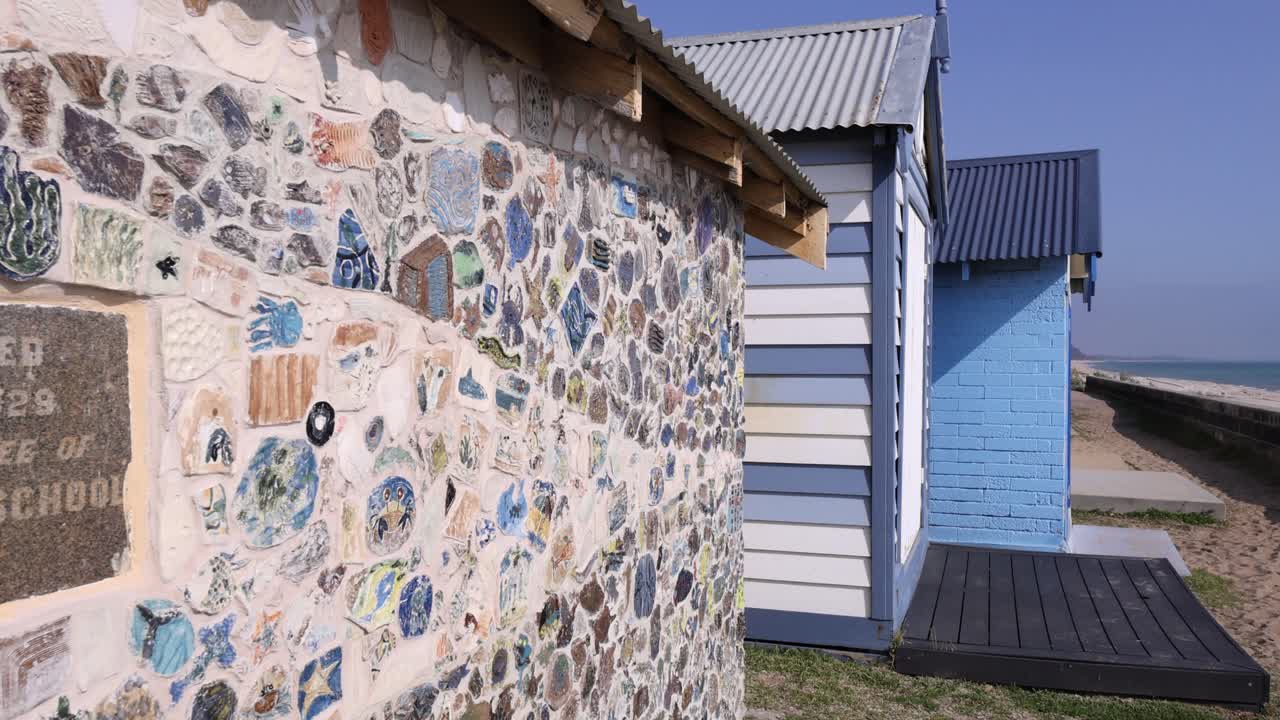 cajas de playa coloridas con arte decorativo en la pared
