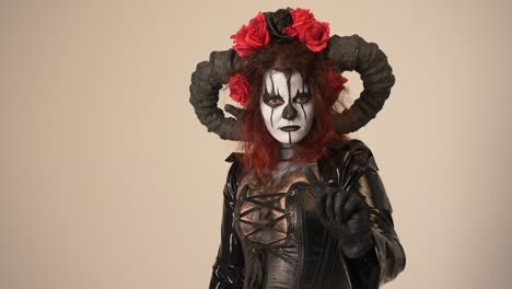 Catrina-Cosplay-Mädchen-Sagt-Nein-Mit-Einem-Finger--Und-Domina-Outfit-Und-Hellem-Hintergrund,-Mittlere-Nahaufnahme