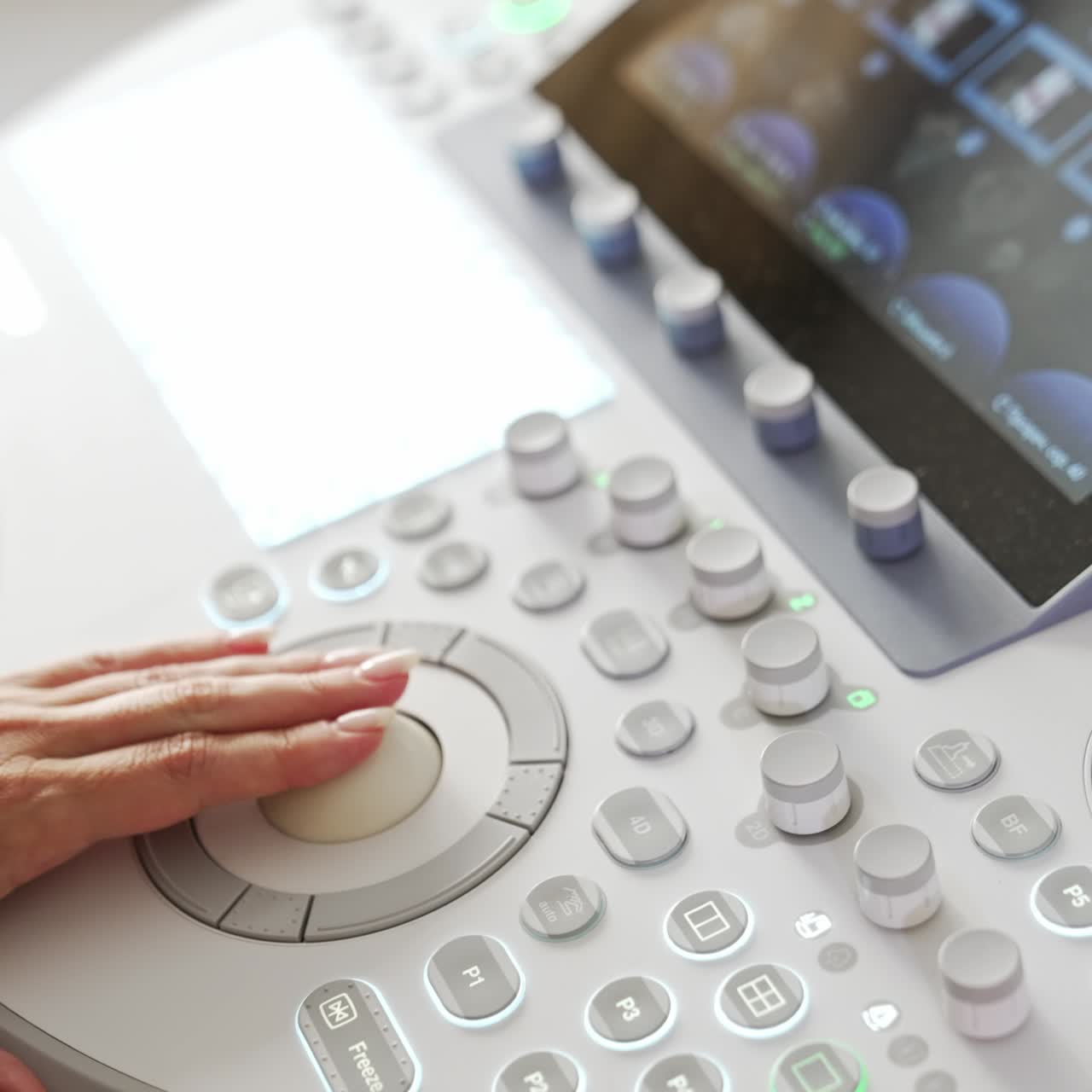 Hand of a female doctor moving by the keyboard on the ultrasound machine. Close up. Modern equipment at maternity hospital