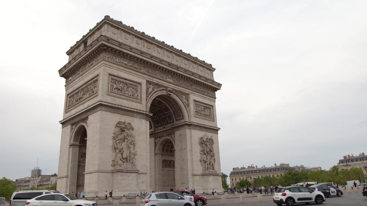 Ampia inquadratura statica dell'Arco di Trionfo con veicoli in transito a Parigi, Francia.