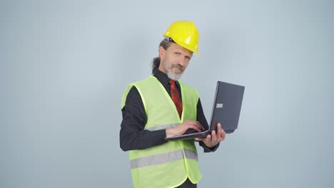 Engineer-holding-laptop-laughing-at-camera.