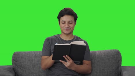 Happy-Indian-man-writing-in-diary-Green-screen
