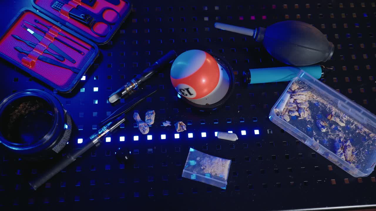 Tabletop with various illicit substances Psilocybin mushroom, bag of MDMA, Weed, THC Vape, and tools