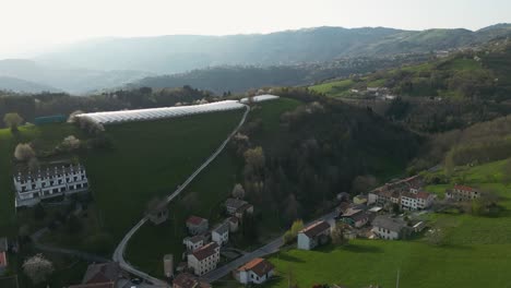 Greenhouse-Farm-On-Hill-With-Hillside-Houses-In-Bassano-del-Grappa,-Veneto,-Italy