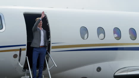 businessman waving at the entrance of private jet 4k