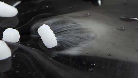 dry ice on dark surface onto which water drips and it's chemical reaction produced smokes. slow