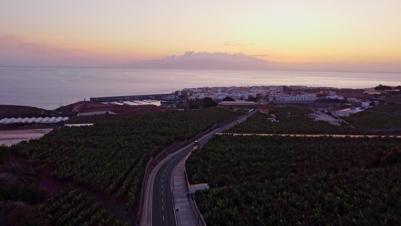 la ciudad costera de san juan y las plantaciones de plátanos en primer plano después del atardecer