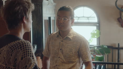 asian collector discussing antiques with female client in vintage shop