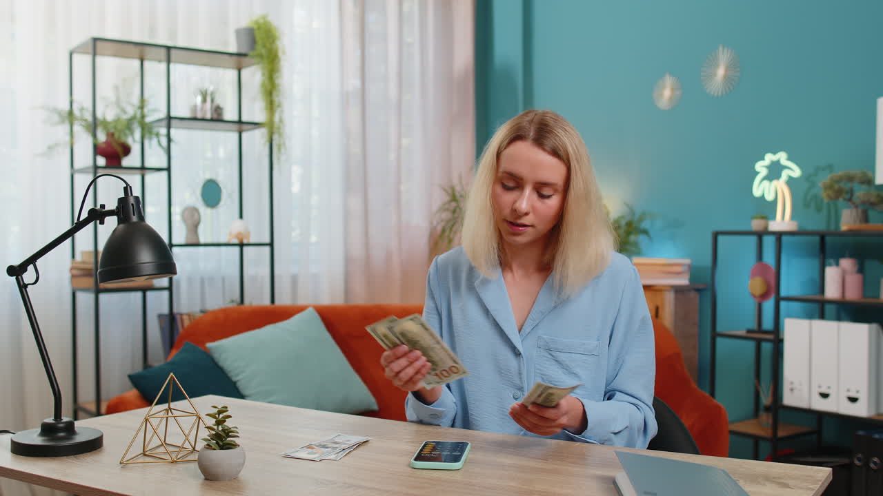 Woman counting money cash use smartphone calculator application calculate income earnings home bills