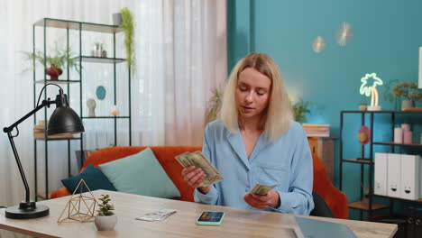 woman counting money cash use smartphone calculator application calculate income earnings home bills