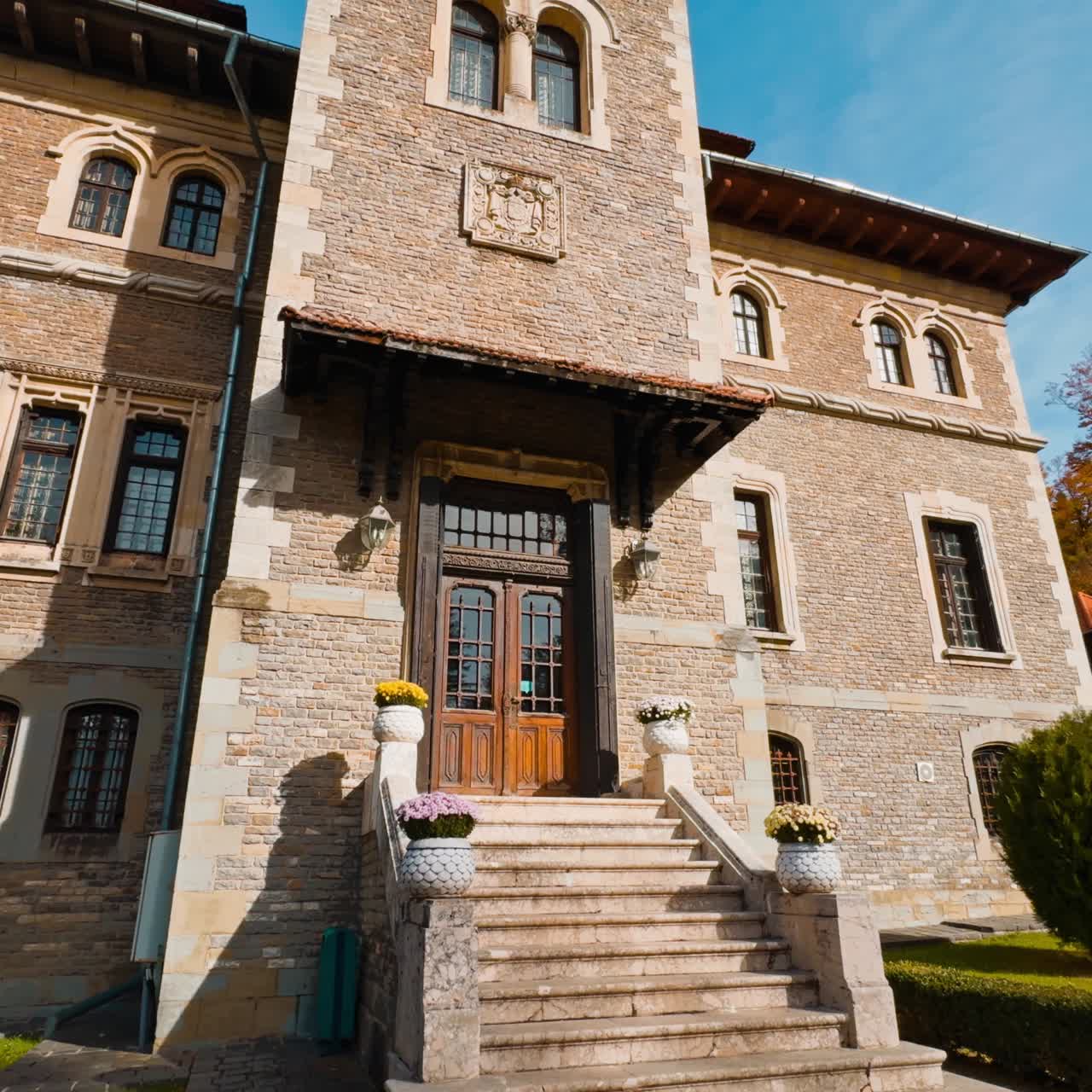 Sulla scalinata dell'antico e splendido palazzo con torre. Castello di Cantacuzino a Busteni, Romania, in una giornata di sole. Vista dal basso.