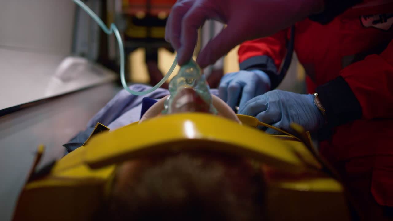 Unrecognizable paramedics rescuing victim in emergency car