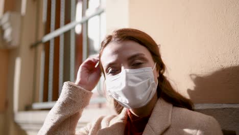 hermosa chica con máscara médica protectora y ropa de moda mira a su alrededor