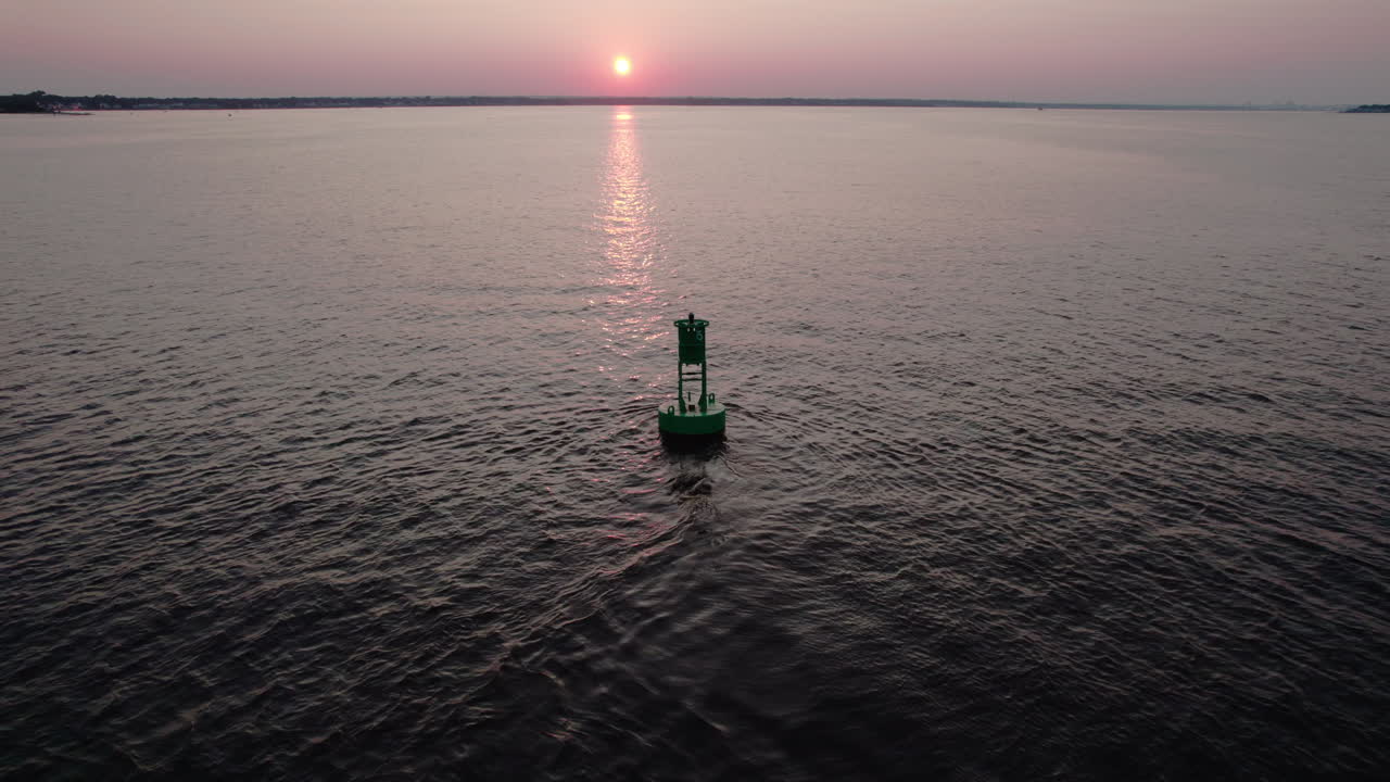 Orbit-video fra luften af en grøn navigationsbøje under solnedgang i Narragansett Bay, Warwick, RI