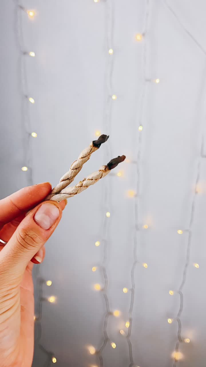 크리스마스 조명 에 대항 하여 불타는  을 들고 있는 손