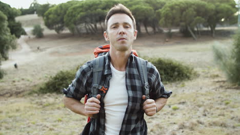 serious hiking guy wearing backpack posing