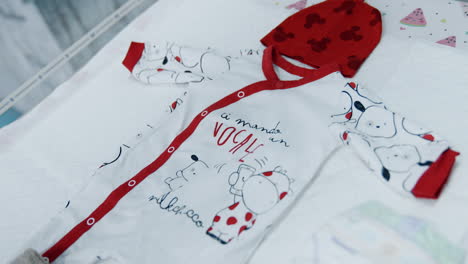 cute baby bodysuit, red cap and warm socks. clothes prepared for a newborn baby in hospital.