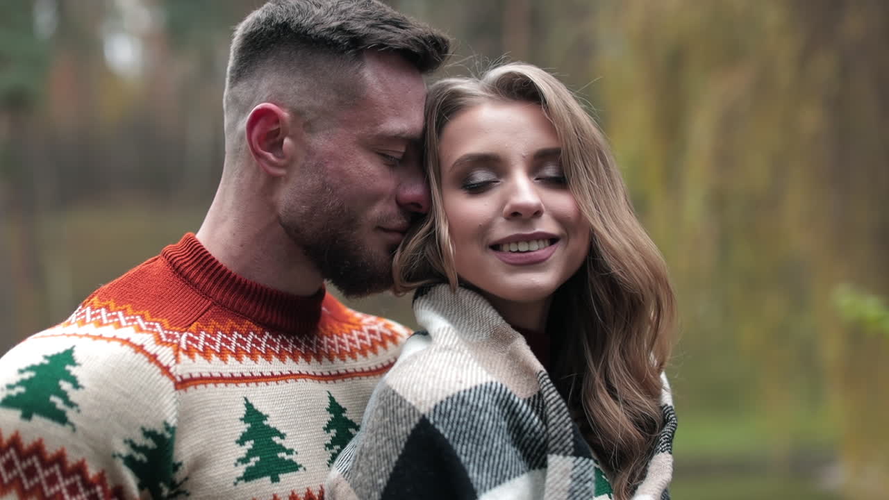 Happy man and woman enjoy being together outdoors. Warm hugs in chilly autumn season. People in love in the nature background.