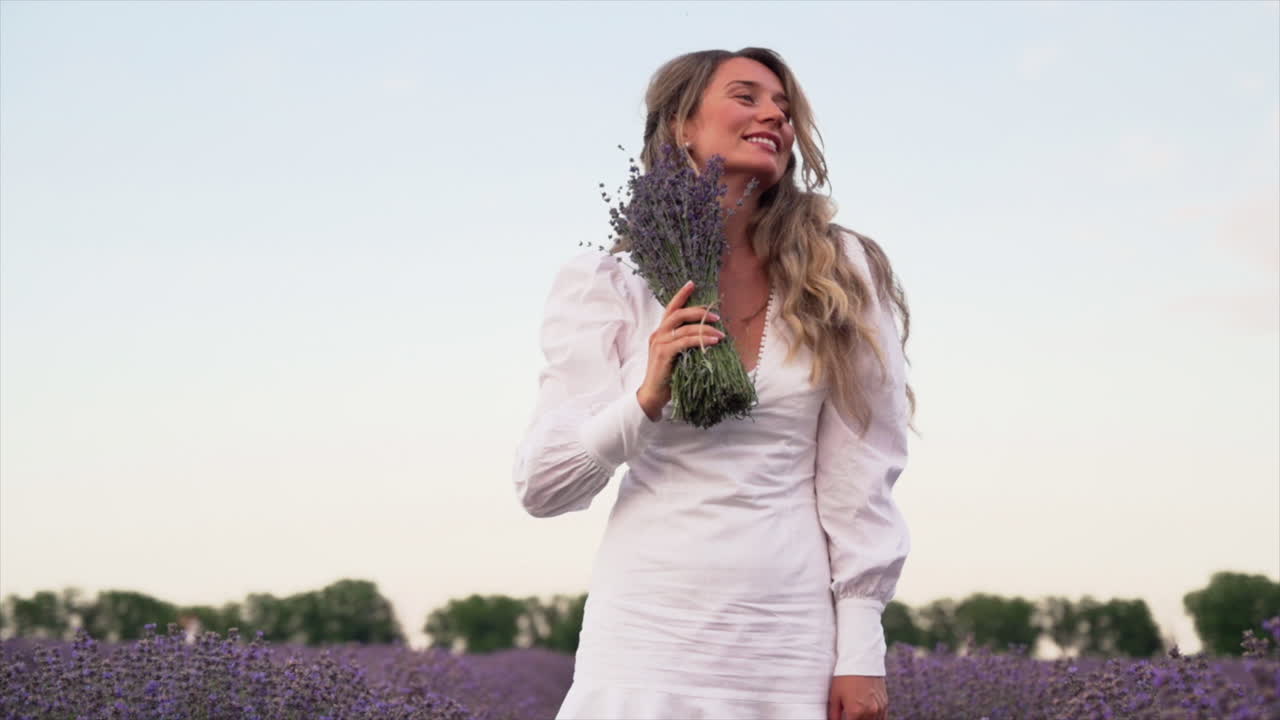 Mujer con un vestido blanco posando en un campo de lavanda