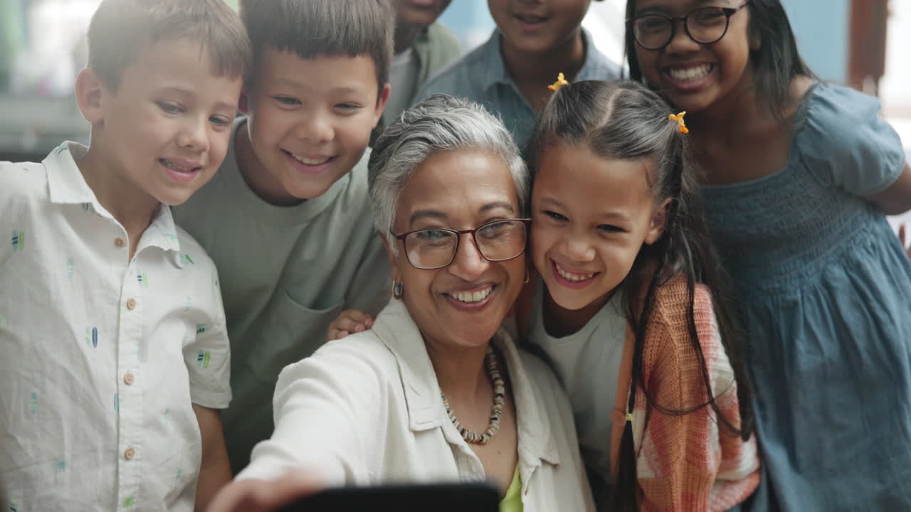 A group of children and a teacher taking a selfie together