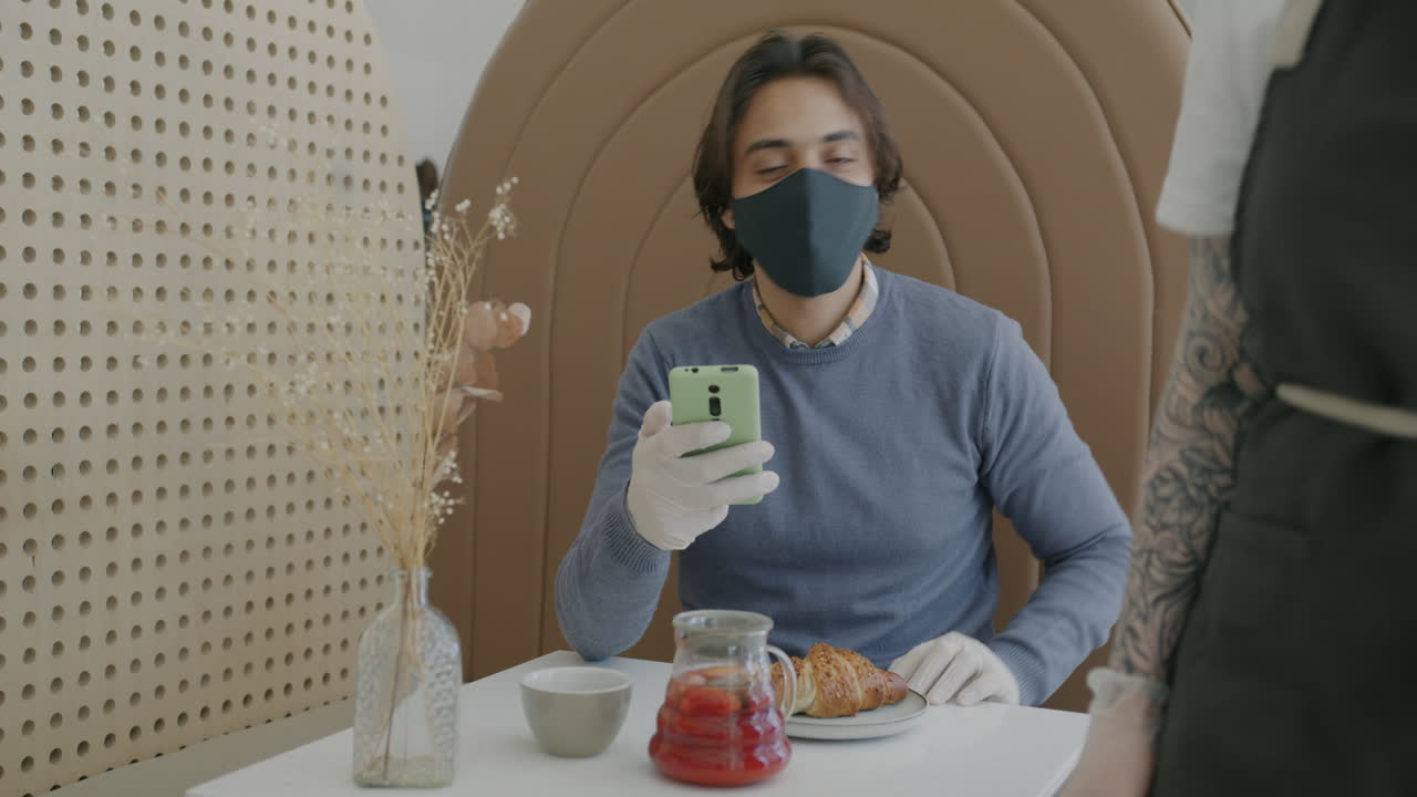 Customer using phone in cafe during Covid-19 pandemic
