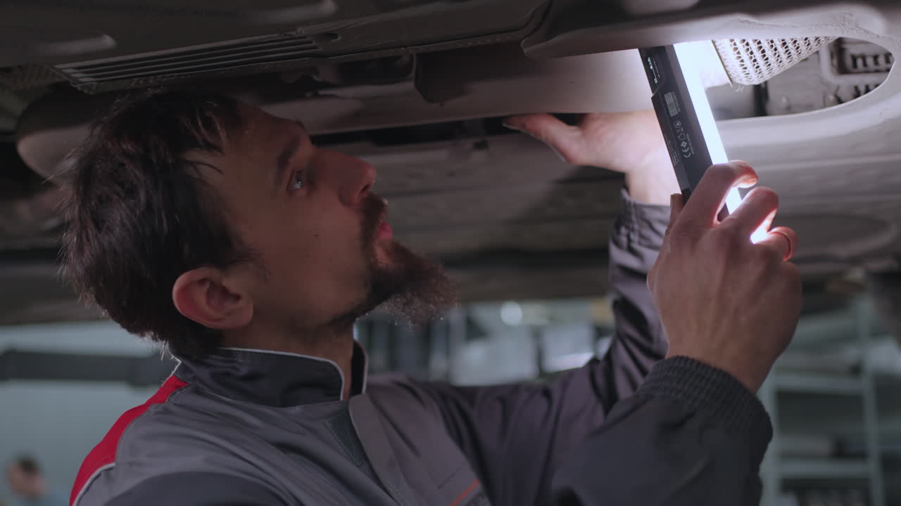 A mechanic inspects the car's exhaust system