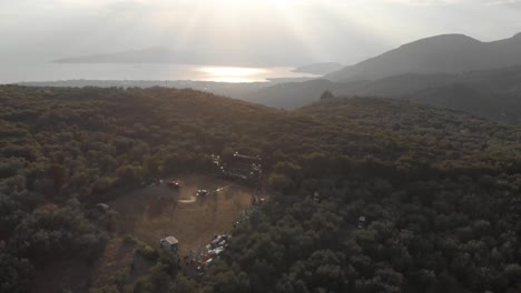 aerial drone footage of amazing landscape mountain with small village and beautiful blue sky with small white clouds amazing aegean sea at background thessaly greece live music stage from above