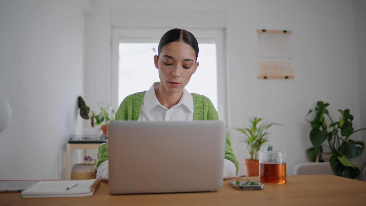 自宅の机でノートパソコンを使う女子学生のクローズアップ。オンラインで学習する女性。