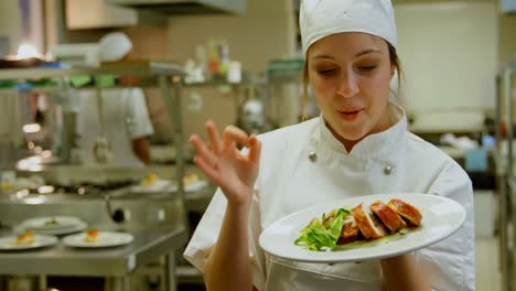 chef femenina sosteniendo el plato y mostrando el signo ok 4k