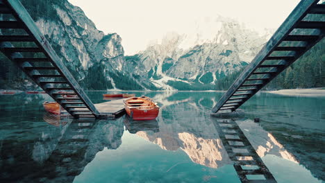 Pasando-Lentamente-Entre-Escaleras-Gemelas-Que-Conducen-Al-Vidrio-Como-Reflejos-En-El-Lago-Braies,-Italia,-Cámara-Lenta