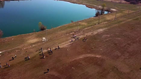 vista aérea de un grupo de personas caminando y ejercitando a sus perros, cerca de la costa