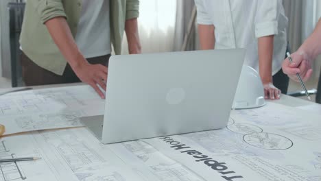close up of group of asian engineers discuss about work on laptop at the office