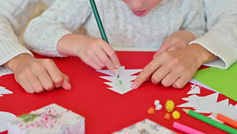 niño colorea un árbol de navidad recortado de papel con un lápiz 1