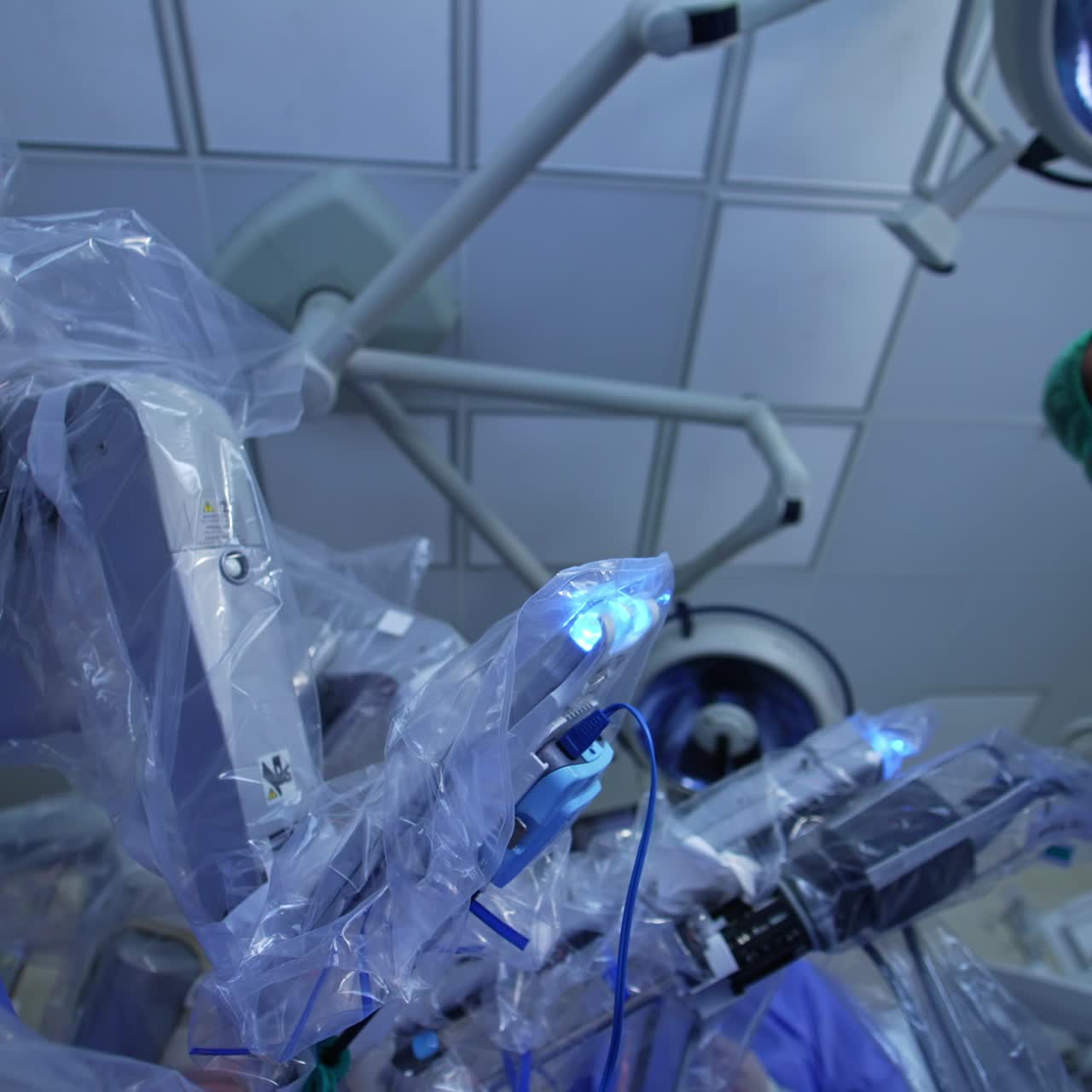Female doctor standing at the operative field of surgeon robot. Healthcare specialist looking at the screen the process of surgery. Low angle view