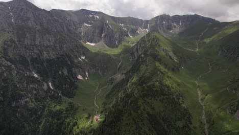 Exuberantes-Montañas-De-Bucegi-Con-Laderas-Verdes-Bajo-Un-Cielo-Nublado,-Toma-Aérea