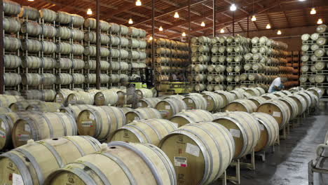 a cellar crew tops off wine barrels during harvest in california wine country